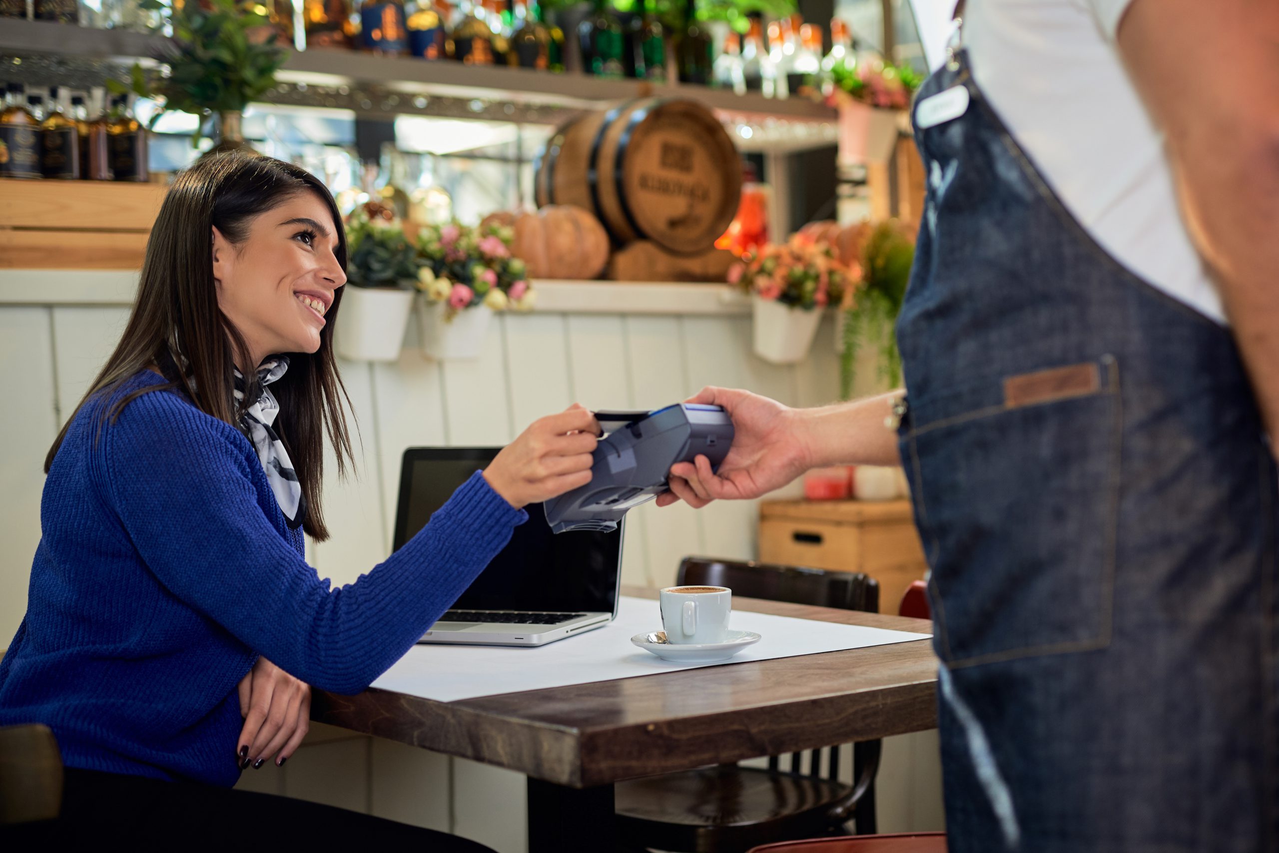 Woman paying her bill in cafe with credit card